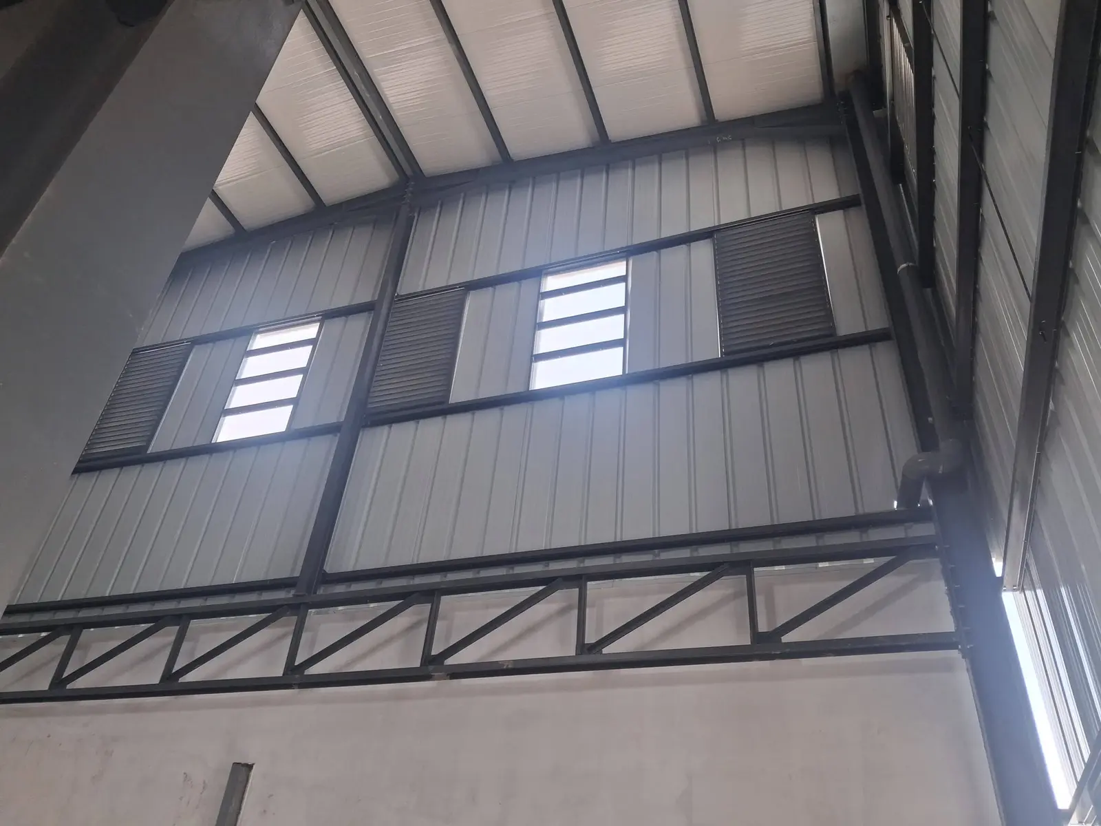 Bardage et charpente apparente à l'intérieur d'un hangar métallique
