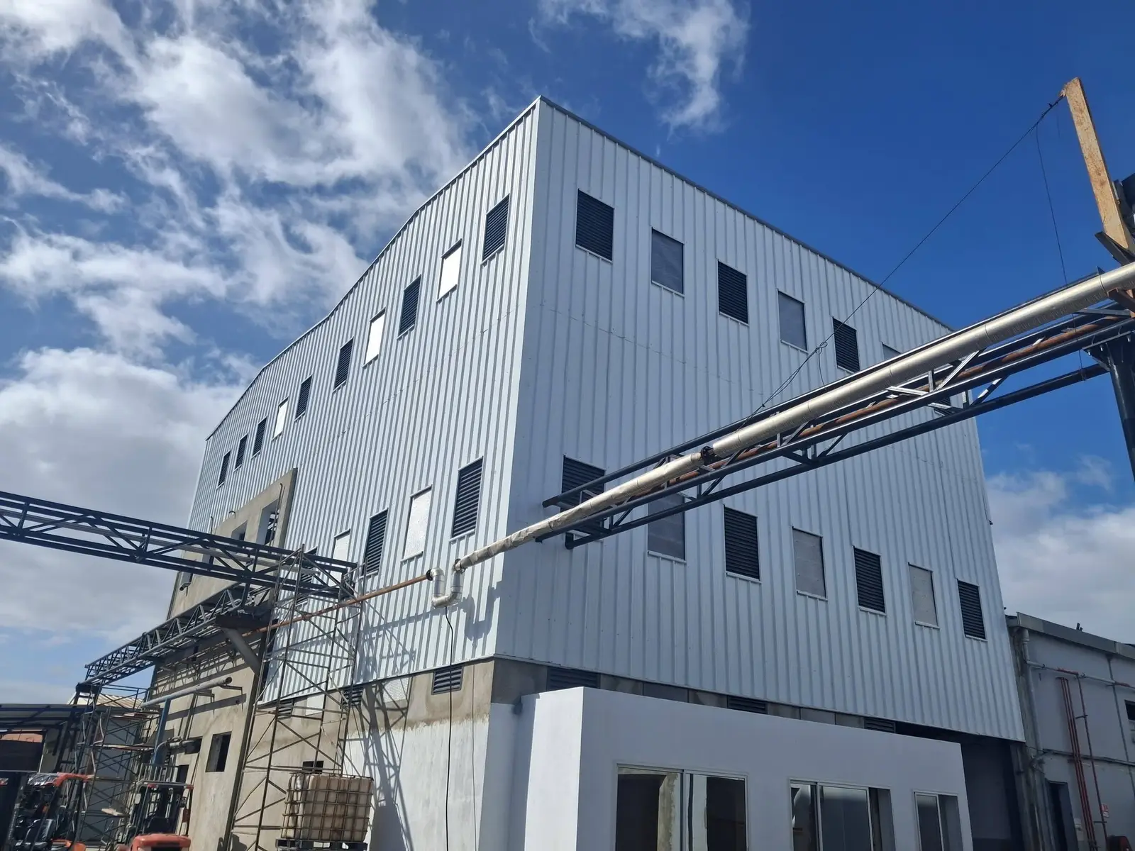 Bâtiment industriel à bardage blanc réalisé en charpente métallique